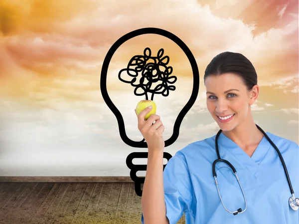 Surgeon holding an apple and smiling at camera — Stock Photo, Image