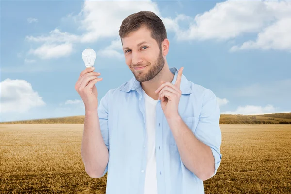 Charming model holding a bulb in right hand — Stock Photo, Image