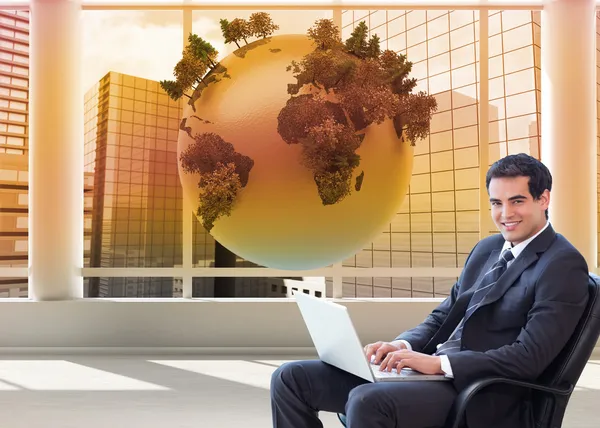 Businessman sitting on an armchair working with a laptop — Stock Photo, Image