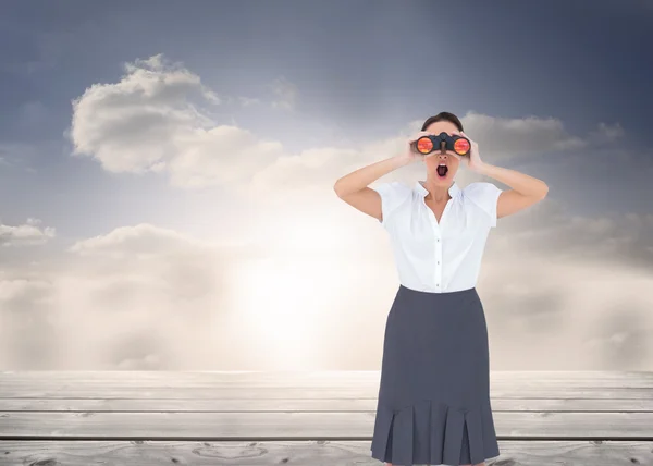 Elegant businesswoman looking through binoculars — Stock Photo, Image