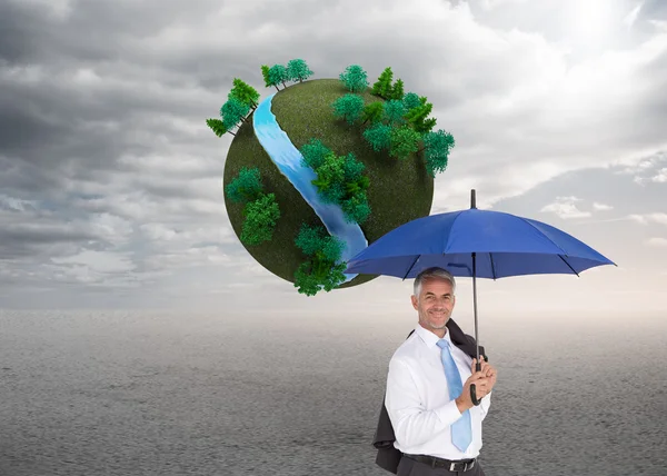Composite image of businessman holding umbrella smiling at camera — Stock Photo, Image