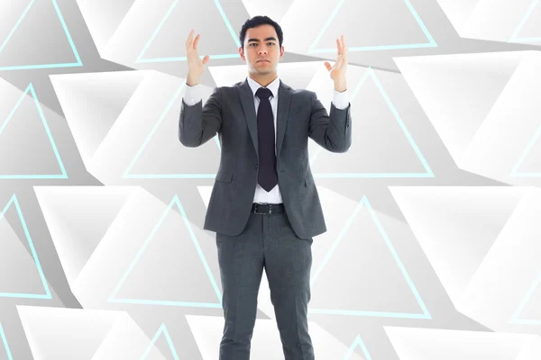 Composite image of unsmiling businessman with arms raised — Stock Photo, Image