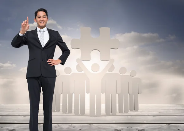 Composite image of smiling asian businessman pointing — Stock Photo, Image