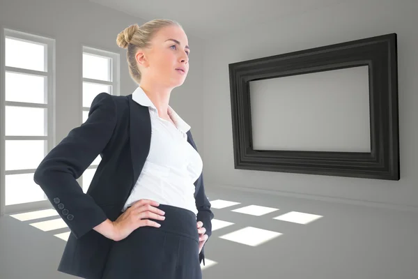 Imagen compuesta de la mujer de negocios de pie con las manos en las caderas —  Fotos de Stock