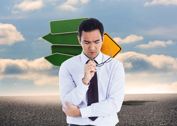 Composite image of thinking businessman holding glasses — Stock Photo, Image