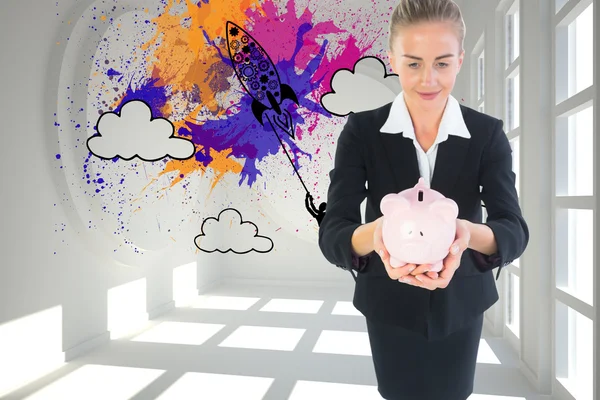 Composite image of businesswoman holding pink piggy bank — Stock Photo, Image