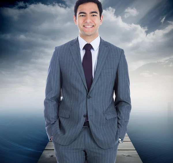 Composite image of smiling businessman standing — Stock Photo, Image