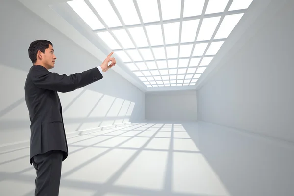 Composite image of serious asian businessman pointing — Stock Photo, Image