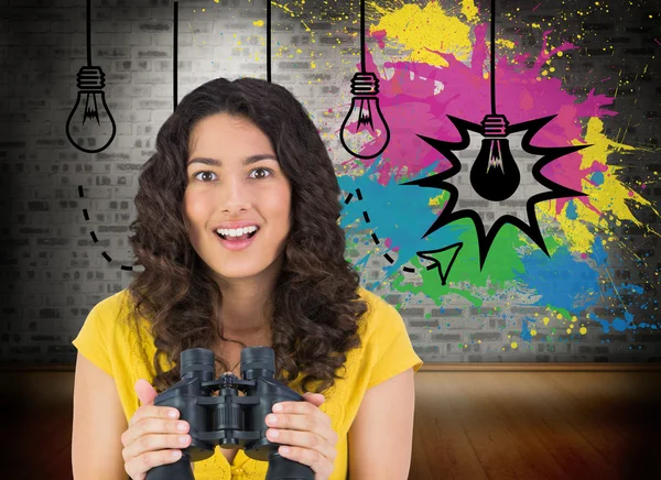 Casual young woman holding binoculars — Stock Photo, Image