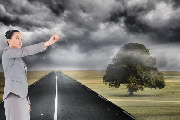 Composite image of unsmiling asian businesswoman pointing — Stock Photo, Image