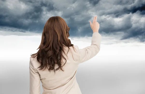 Composite image of brunette businesswoman standing back to camera — Stock Photo, Image