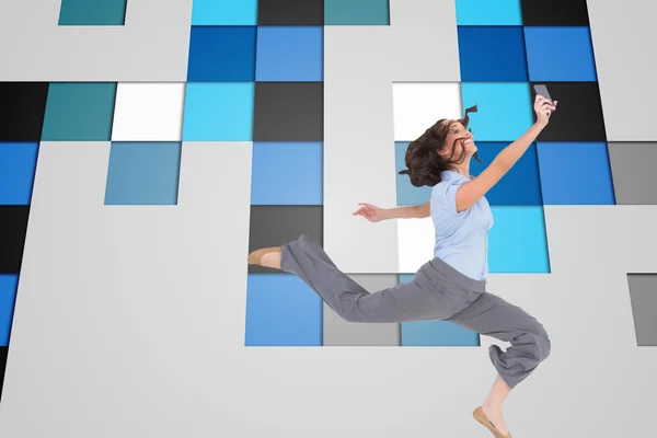 Classy businesswoman jumping while holding smartphone — Stock Photo, Image