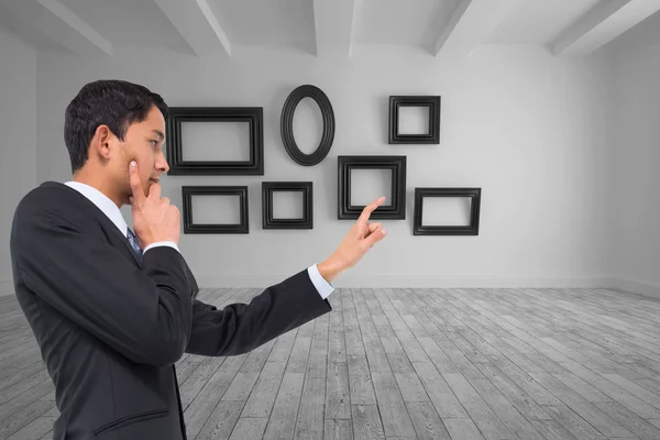 Composite image of thoughtful asian businessman pointing — Stock Photo, Image