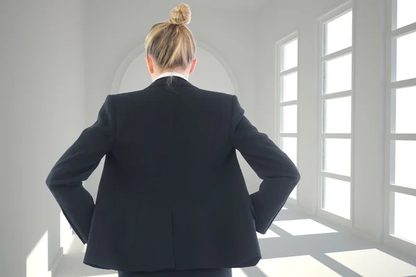 Blonde zakenvrouw permanent met handen op de heupen — Stockfoto