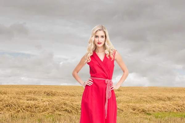 Elegante rubia de pie manos en las caderas en vestido rojo —  Fotos de Stock