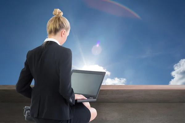 Imagen compuesta de la mujer de negocios utilizando el ordenador portátil —  Fotos de Stock