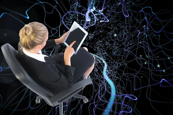 Composite image of businesswoman sitting on swivel chair with tablet — Stock Photo, Image