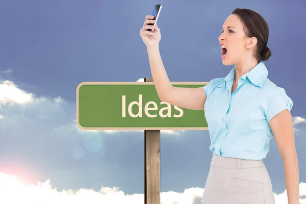 Composite image of angry classy businesswoman yelling at her smartphone — Stock Photo, Image