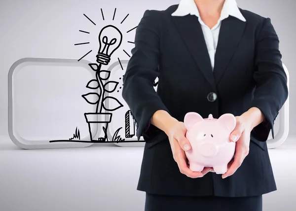 Composite image of businesswoman holding piggy bank — Stock Photo, Image