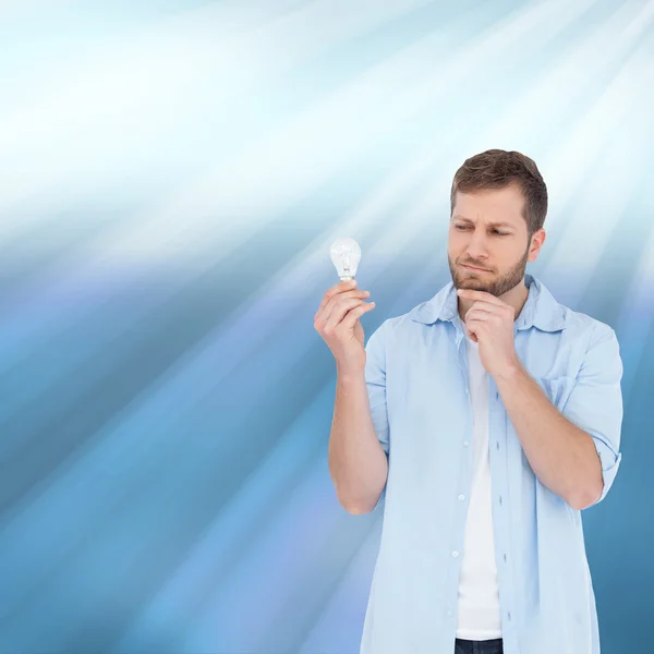 Sceptical model holding a bulb — Stock Photo, Image