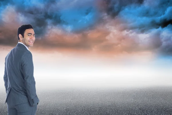 Composite image of smiling businessman standing — Stock Photo, Image