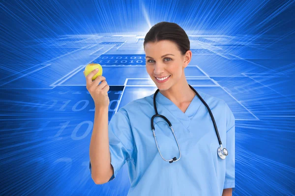 Surgeon holding an apple and smiling at camera — Stock Photo, Image