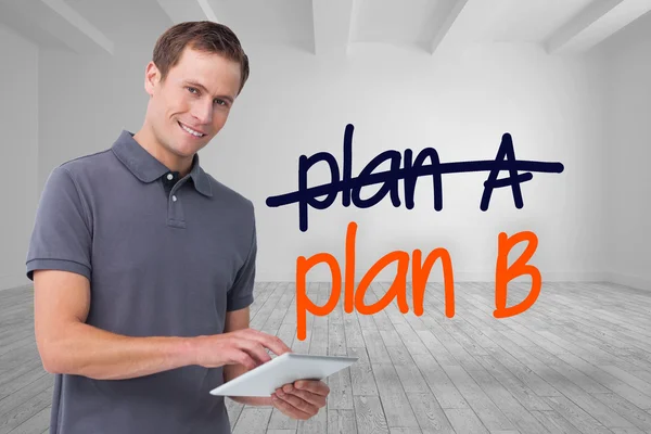 Composite image of smiling young man with tablet computer — Stock Photo, Image