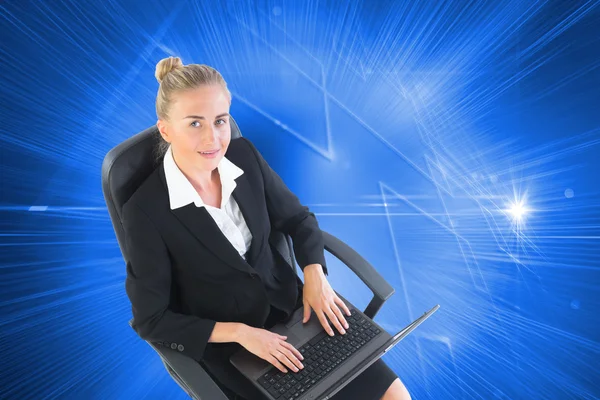 Композитный образ деловой женщины, сидящей на вращающемся стуле с ноутбуком — стоковое фото