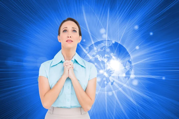 Composite image of troubled young businesswoman praying — Stock Photo, Image