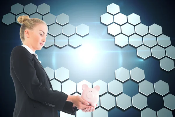 Composite image of businesswoman holding piggy bank — Stock Photo, Image