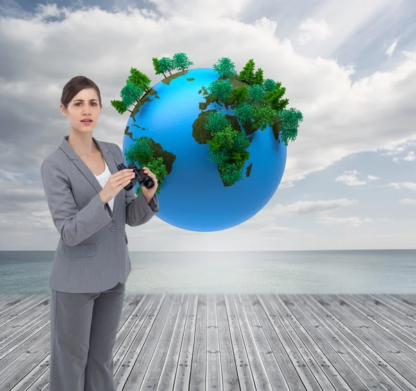 Curious young businesswoman posing with binoculars — Stock Photo, Image