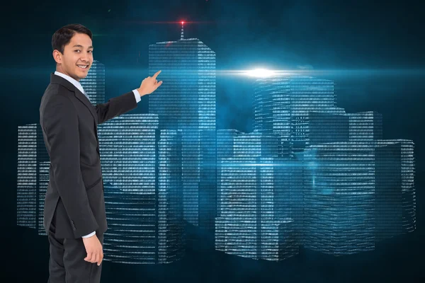 Composite image of smiling asian businessman pointing — Stock Photo, Image