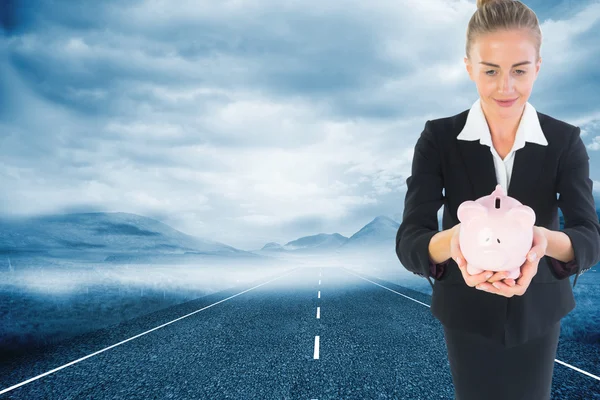 Złożony obraz bizneswoman gospodarstwa różowa skarbonka — Zdjęcie stockowe