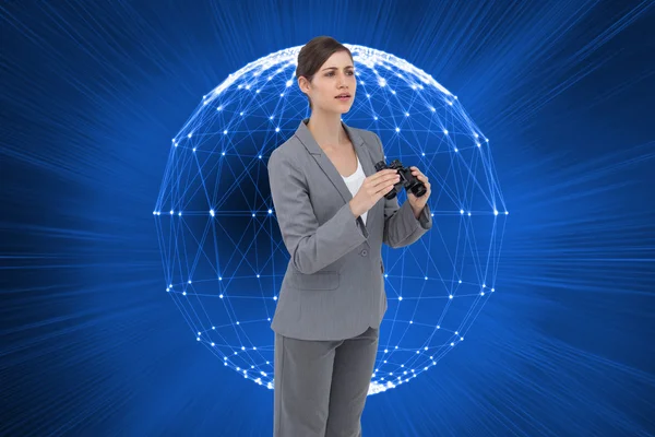 Curious young businesswoman with binoculars — Stock Photo, Image