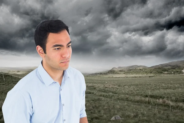 Composite image of unsmiling casual man standing — Stock Photo, Image