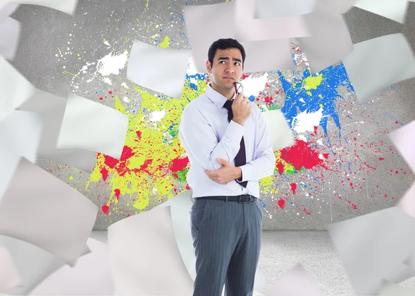 Composite image of thinking businessman holding glasses — Stock Photo, Image