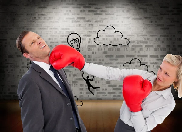 Businesswoman hitting colleague with her boxing gloves — Stock Photo, Image
