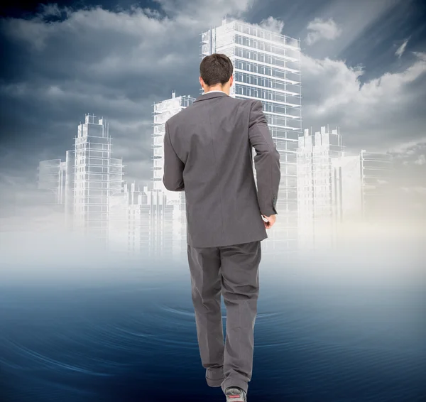 Composite image of young businessman walking away from camera — Stock Photo, Image