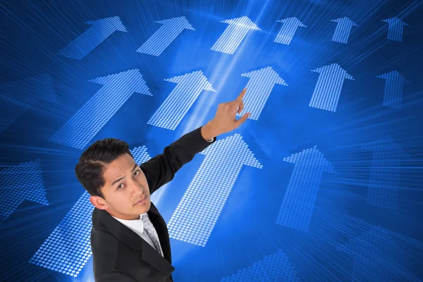 Composite image of unsmiling asian businessman pointing — Stock Photo, Image