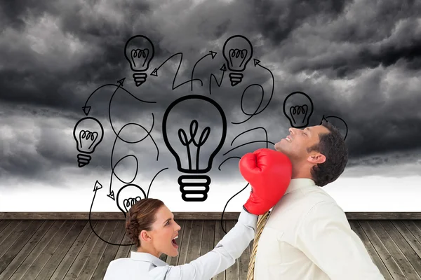 Businesswoman hitting a businessman with boxing gloves — Stock Photo, Image