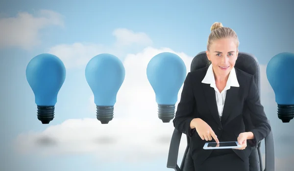 Composite image of businesswoman sitting on swivel chair with tablet — Stock Photo, Image