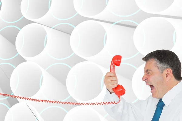 Businessman screaming directly into the handset — Stock Photo, Image