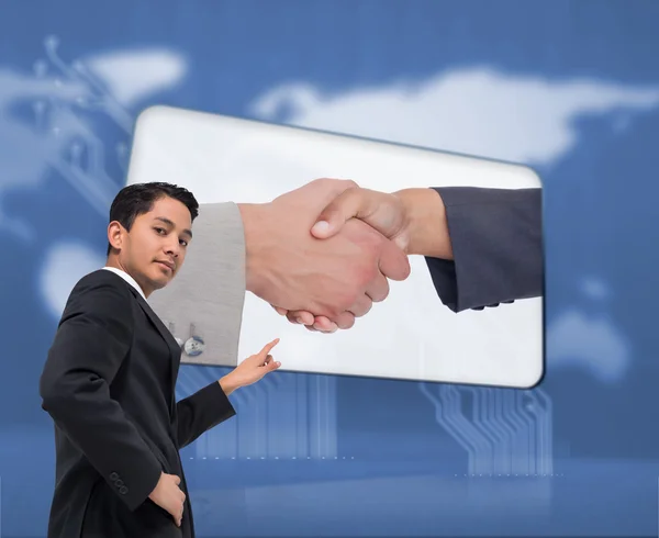 Composite image of unsmiling asian businessman pointing — Stock Photo, Image