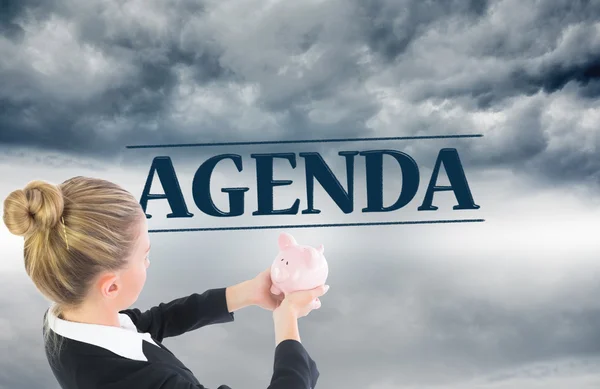 Composite image of businesswoman holding pink piggy bank — Stock Photo, Image