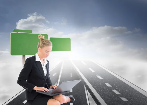 Composite image of businesswoman using laptop — Stock Photo, Image