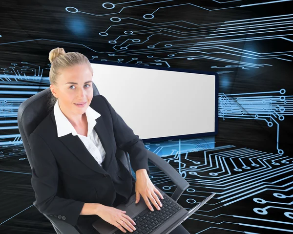 Kompositbild einer Geschäftsfrau auf Drehstuhl mit Laptop — Stockfoto