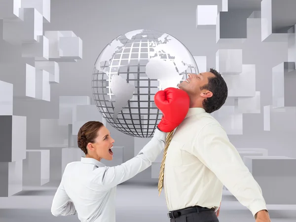 Businesswoman hitting a businessman with boxing gloves — Stock Photo, Image