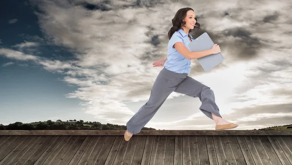 Businesswoman jumping while holding clipboard — Stock Photo, Image