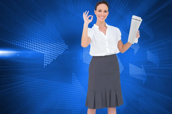 Composite image of stylish businesswoman making gesture while holding newspaper — Stock Photo, Image