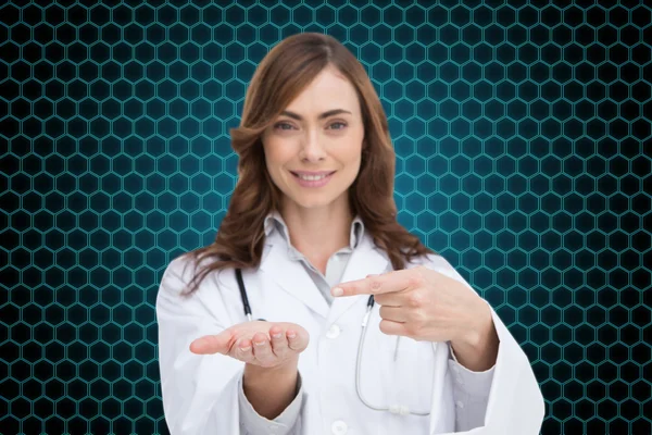 Lachende arts presenteren van haar hand — Stockfoto